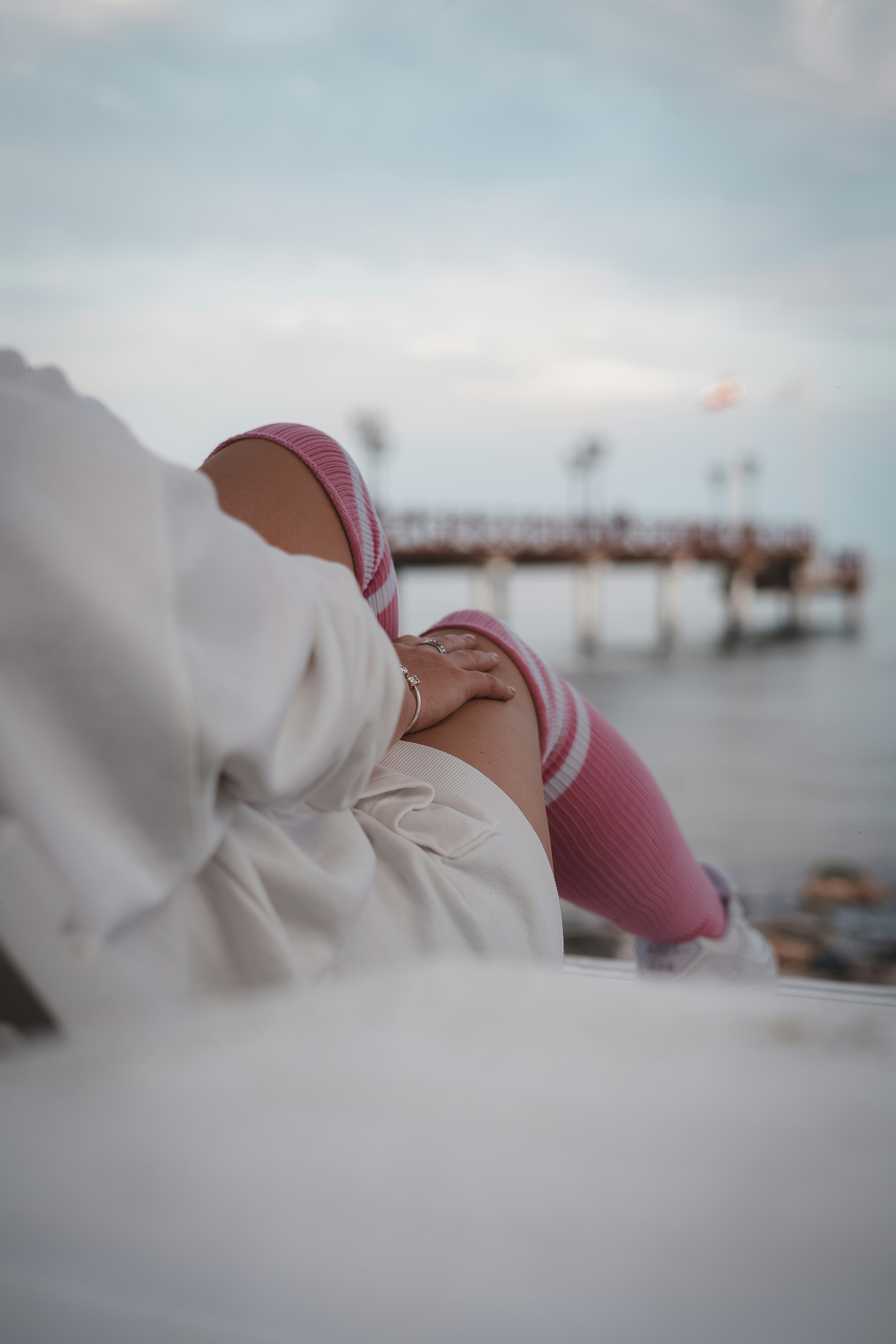 person in white coat and pink underwear lying on white textile